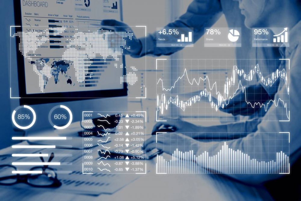 graphs and data sets overlaying image of two men looking at data on a computer